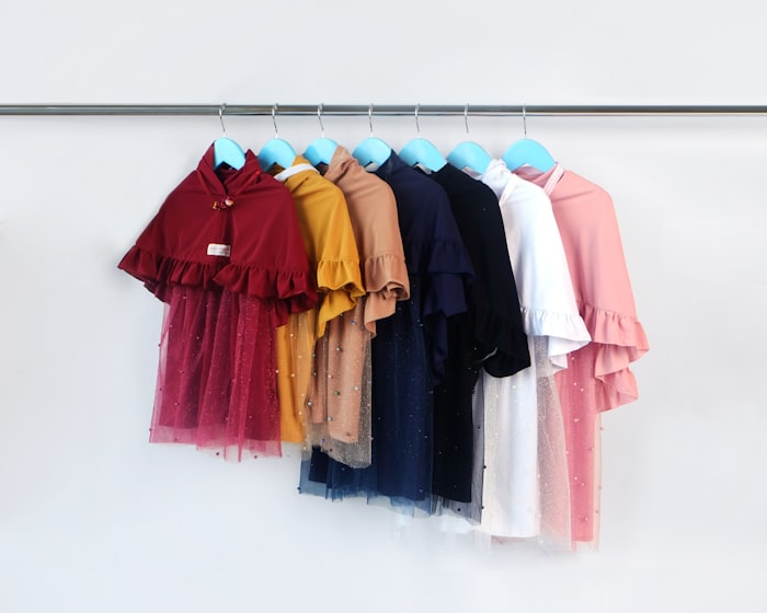 A row of colorful children's tops on hangers